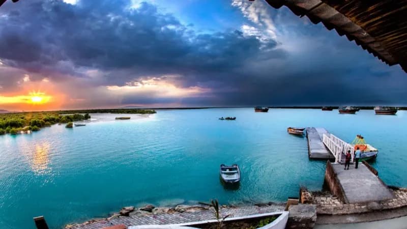 زوج در حال تماشای غروب خورشید در ساحل قشم