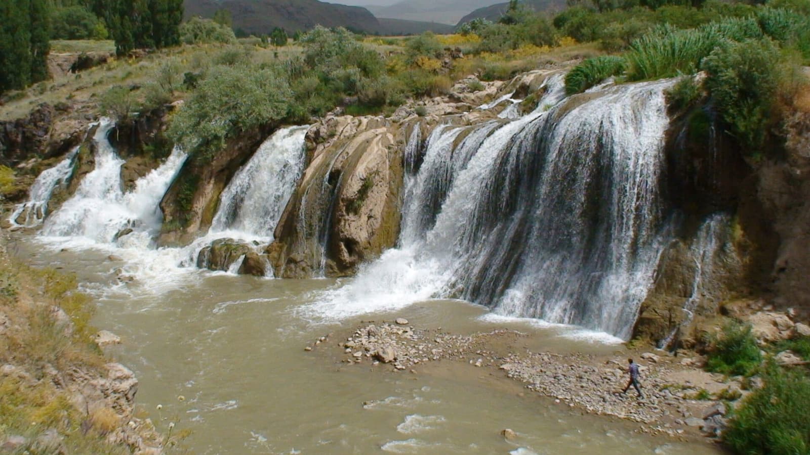 آبشار پلکانی مرادیه با جریان آب کف‌آلود در میان طبیعت سرسبز اطراف وان