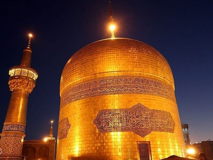 گنبد طلایی و گلدسته زرین حرم رضوی در نور طلایی هنگام غروب