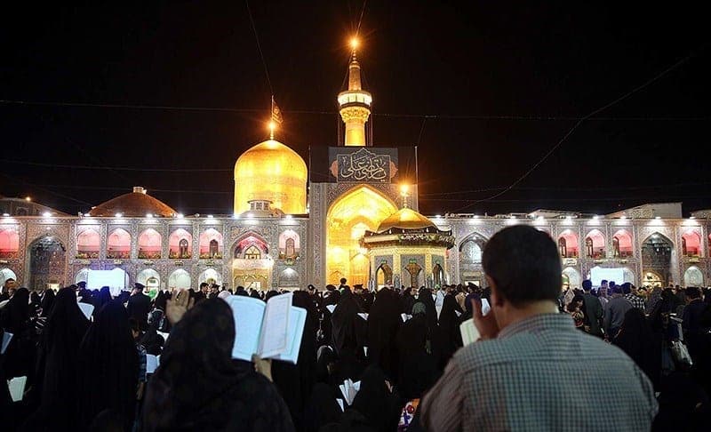 صحن حرم امام رضا در شب قدر با گنبد و ایوان طلایی نورانی و زائران در حال نیایش