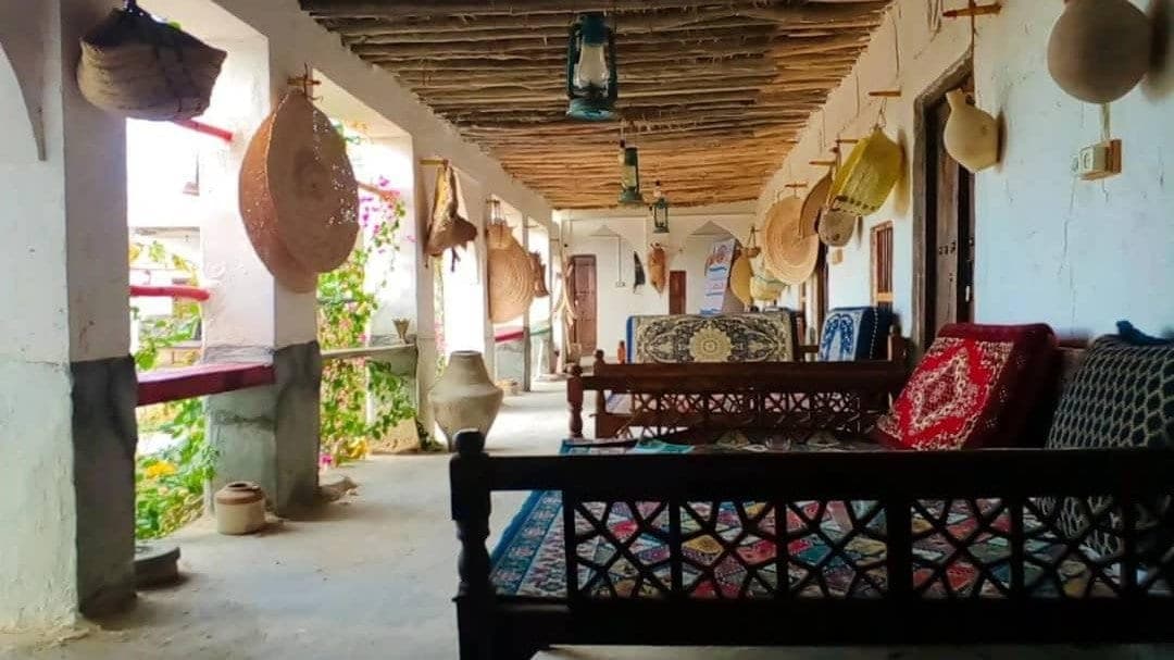 ایوان نشیمن با تخت سنتی و پشتی‌های رنگی در بوم‌گردی ناخدا علی قشم