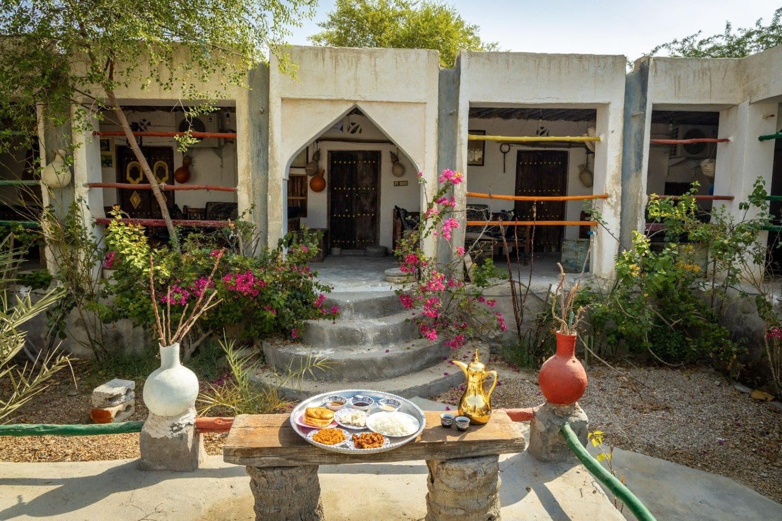 حیاط مرکزی با باغچه و معماری قوسی در بوم‌گردی ناخدا علی قشم