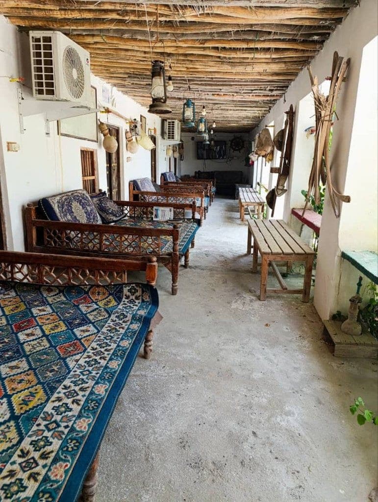 راهرو و ایوان سرپوشیده با ستون و کف‌پوش سنتی در بوم‌گردی ناخدا علی قشم