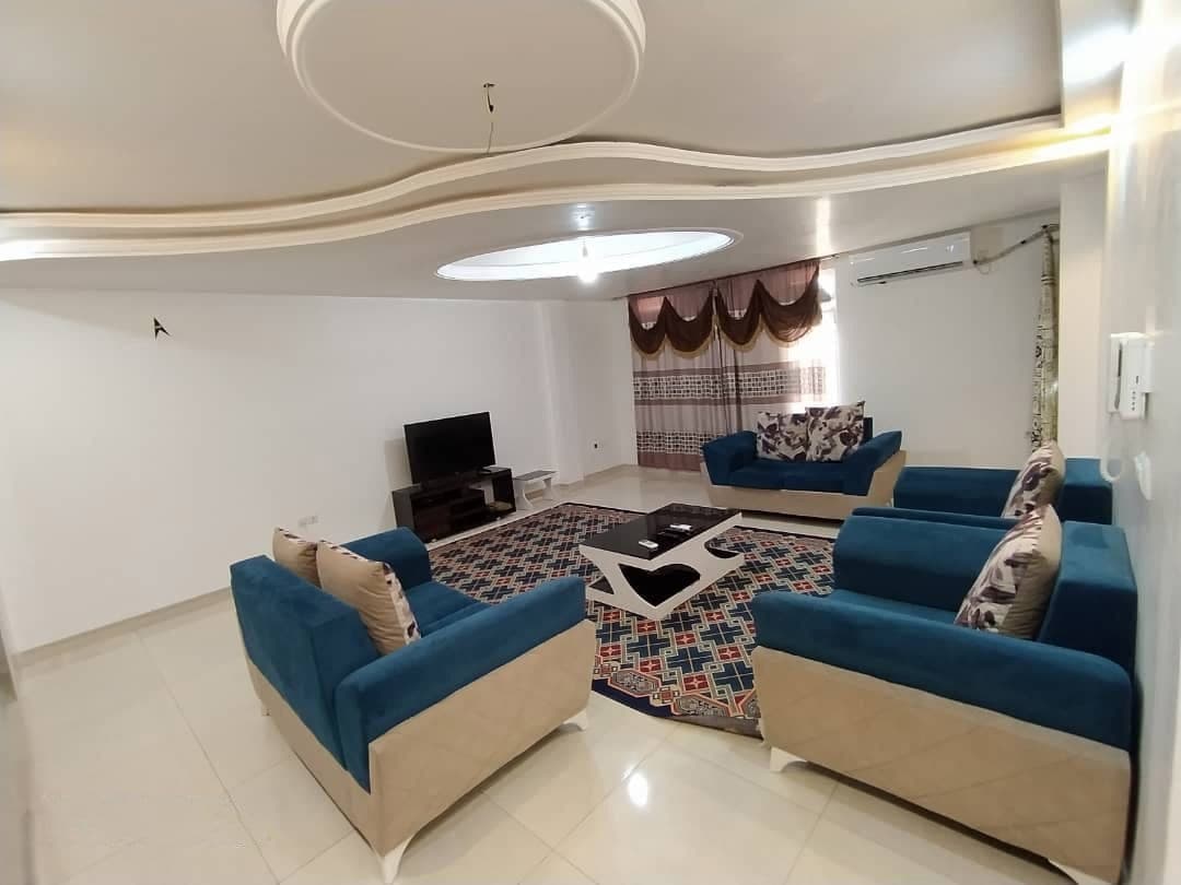 نشیمن دلباز با مبل آبی و تلویزیون در آپارتمان سام ۱ واحد ۷ قشم