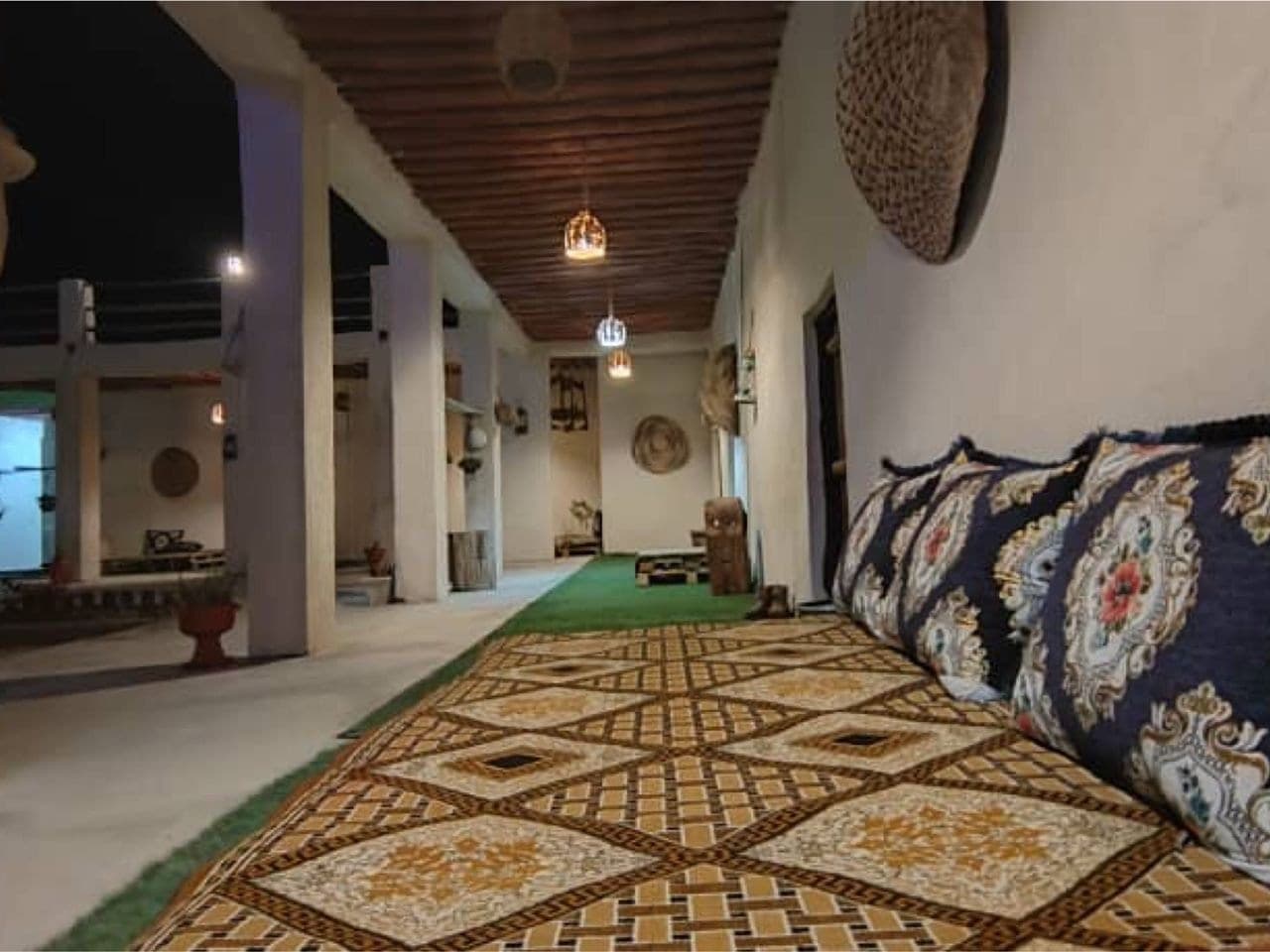 اتاقِ سنتی با رخت‌خوابِ بومی روی فرش در بوم‌گردی چیرا قشم