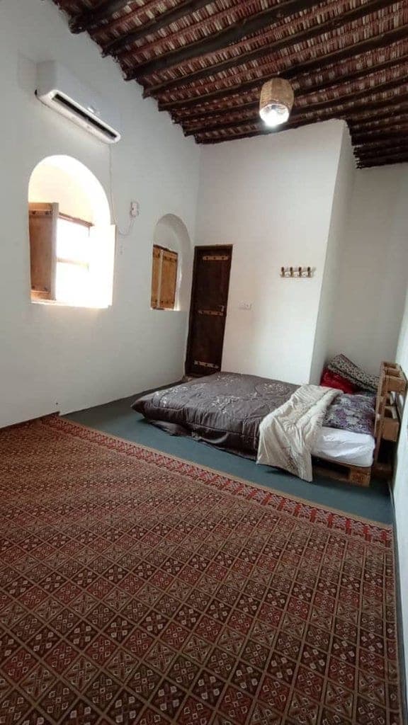 نمای بیرونیِ ساختمانِ سنتیِ دوطبقه در غروب در بوم‌گردی چیرا قشم