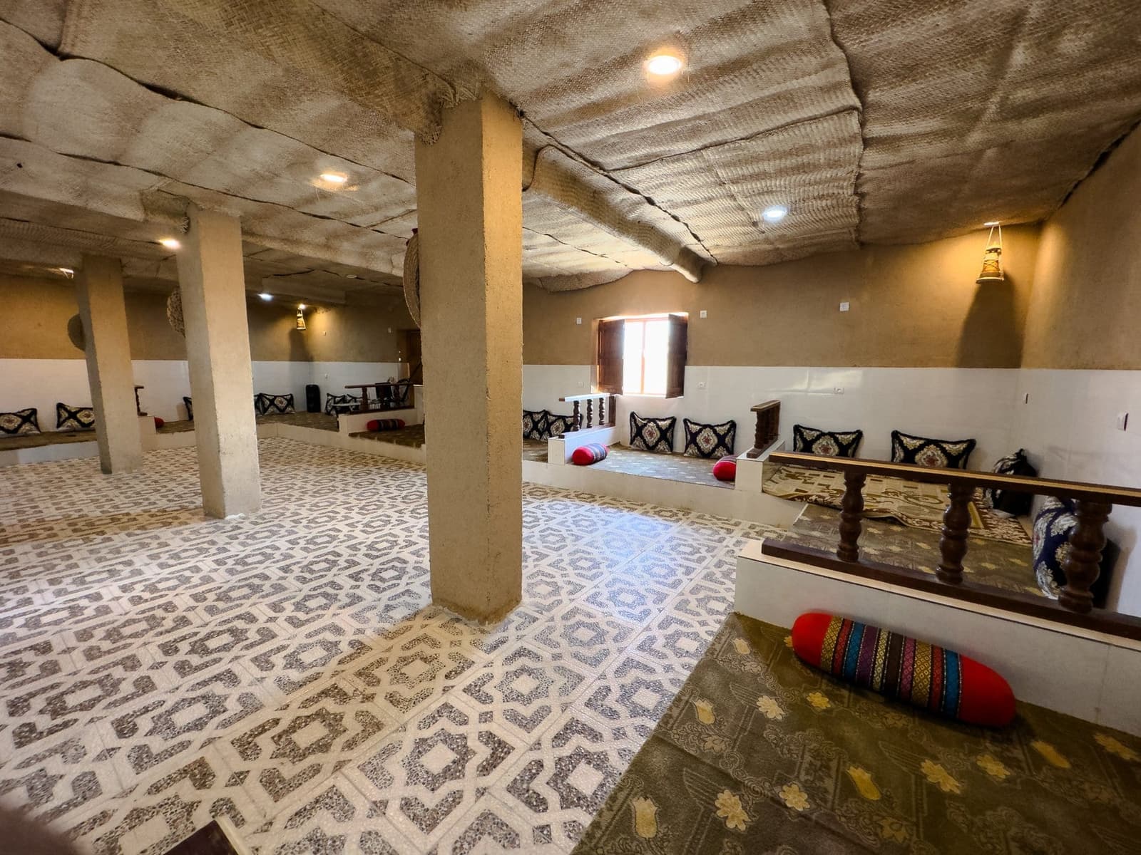 سالنِ پذیراییِ سنتی با ستون و کفِ کاشی در بوم‌گردی چیرا قشم