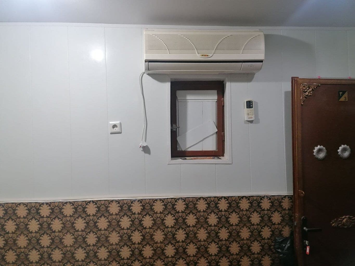 دیوار اتاق با کولر گازی، پنجره و درب ورودی سوئیت طوفان درگهان قشم