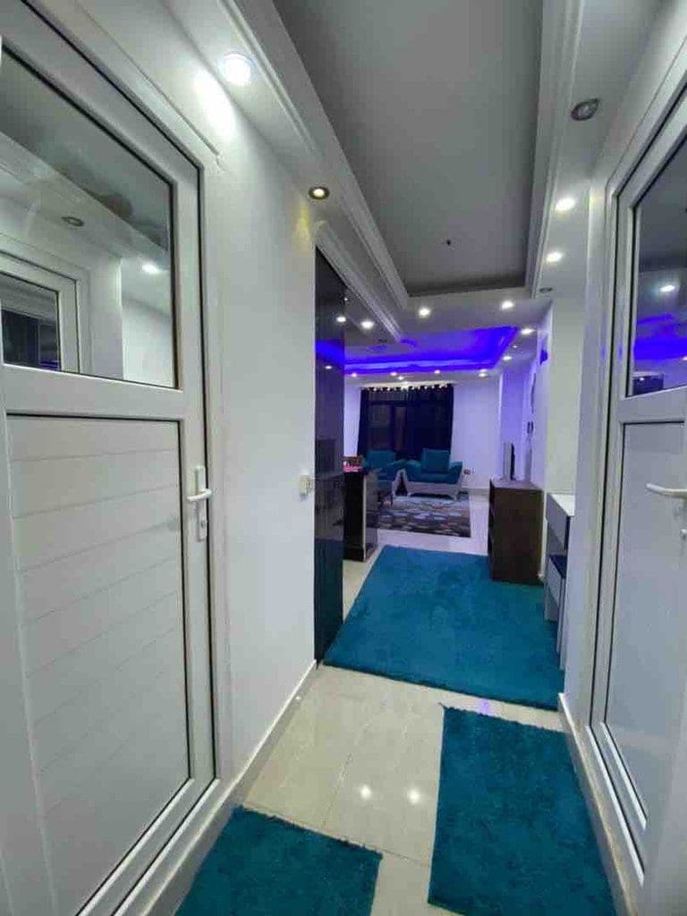 اتاق‌خواب با تخت‌های یک‌نفره و نورپردازی مدرن در آپارتمان لوکس سام پلاس ۱ قشم