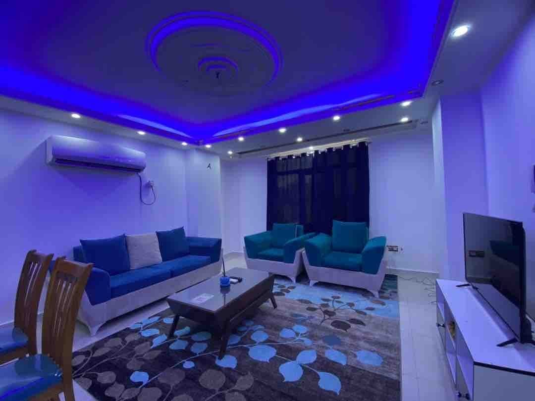 فضای نشیمن و نهارخوری با مبلمان فیروزه‌ای در آپارتمان لوکس سام پلاس ۱ قشم