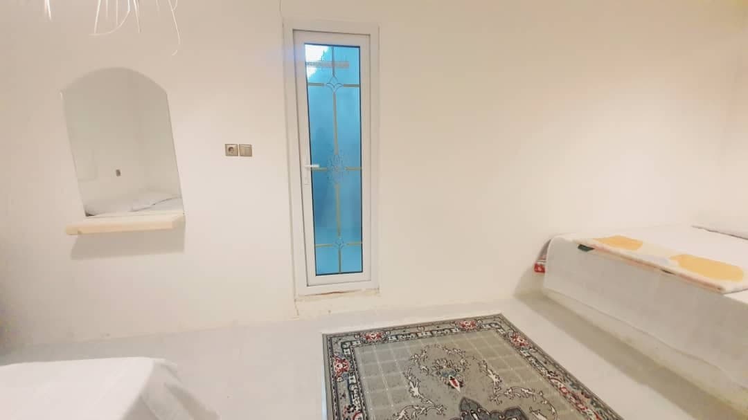محوطهٔ سنگ‌فرش با درختان و نورپردازی شبانه در بوم‌گردی مالوک قشم