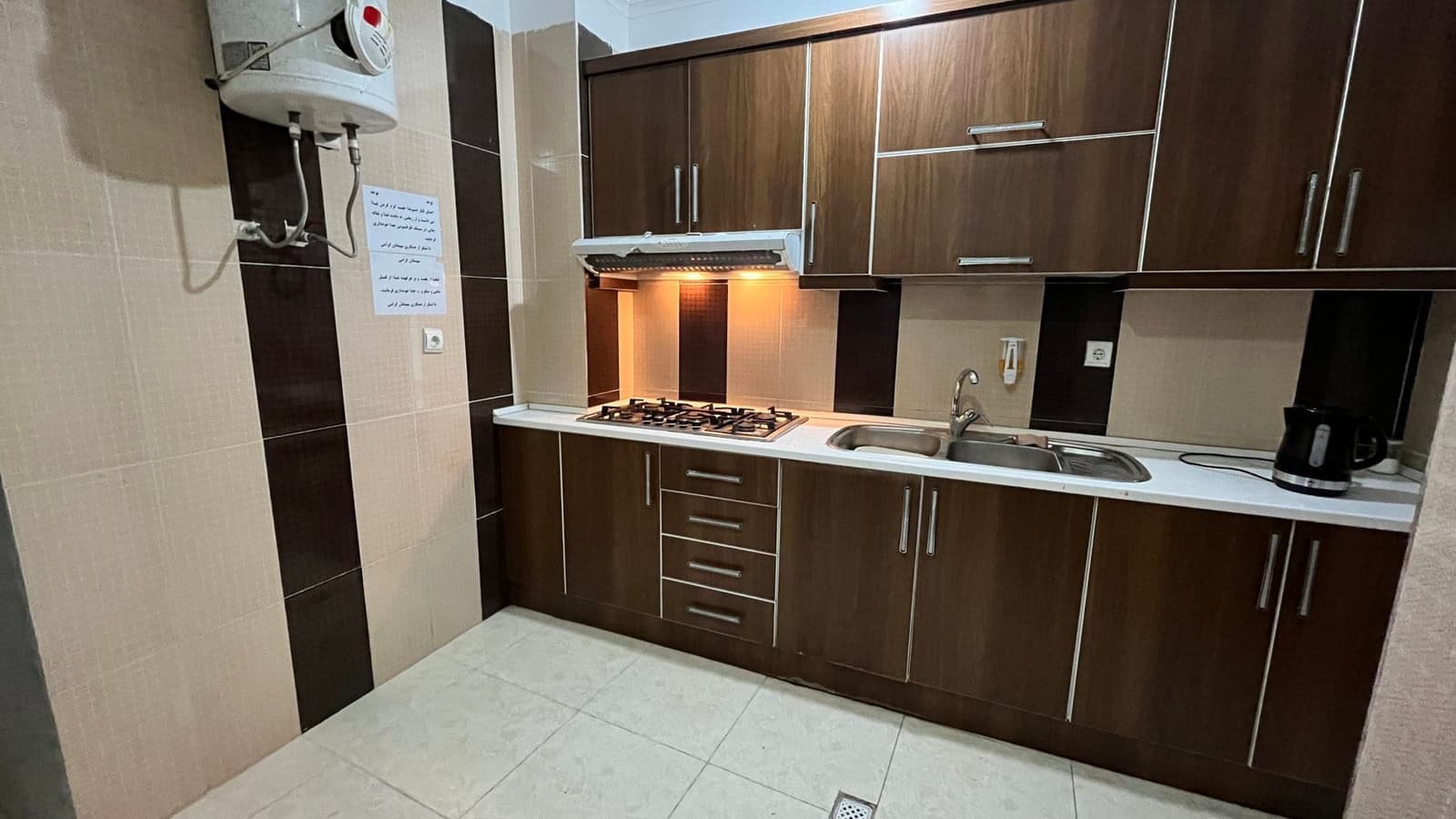 آشپزخانهٔ مشترک با کابینت و اجاق گاز در مسافرخانه محسن قشم