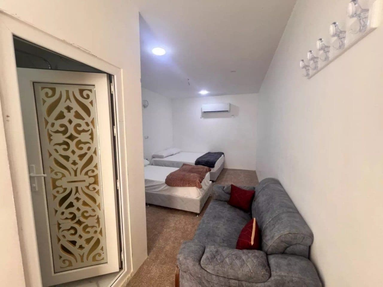 نشیمن با پانل تزیینی مشبک و مبل رو به حیاط در بوم‌گردی خماسی هنگام