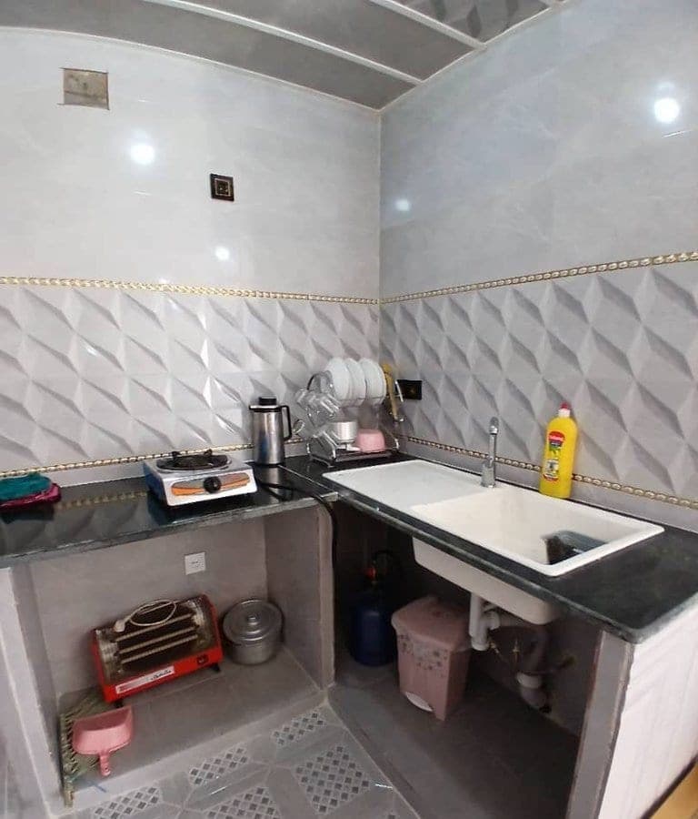 سینک و فضای آشپزخانه با کاشی خاکستری در سوئیت قائدی قشم