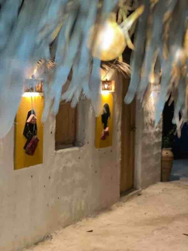 نمای شبانهٔ حیاط با چراغ‌ها و طاقچه‌های تزئینی در اقامتگاه سنتی خانه شیوا هرمز