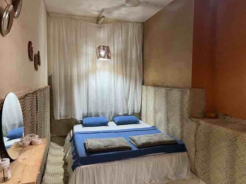اتاق‌خواب واحد آبی با تخت دونفره، پرده و رخت‌خواب آبی در اقامتگاه خانه شیوا هرمز