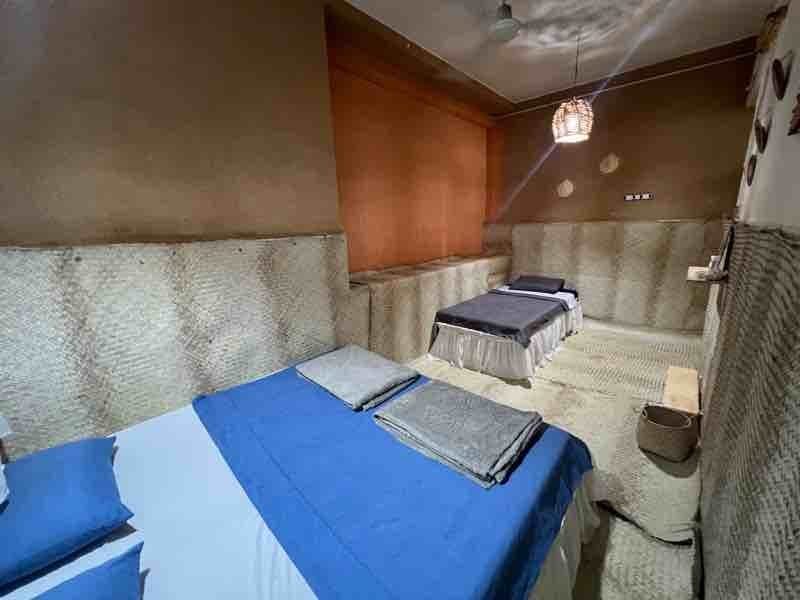 اتاق با دو تخت و رخت‌خواب آبیِ سنتی در اقامتگاه سنتی خانه شیوا هرمز
