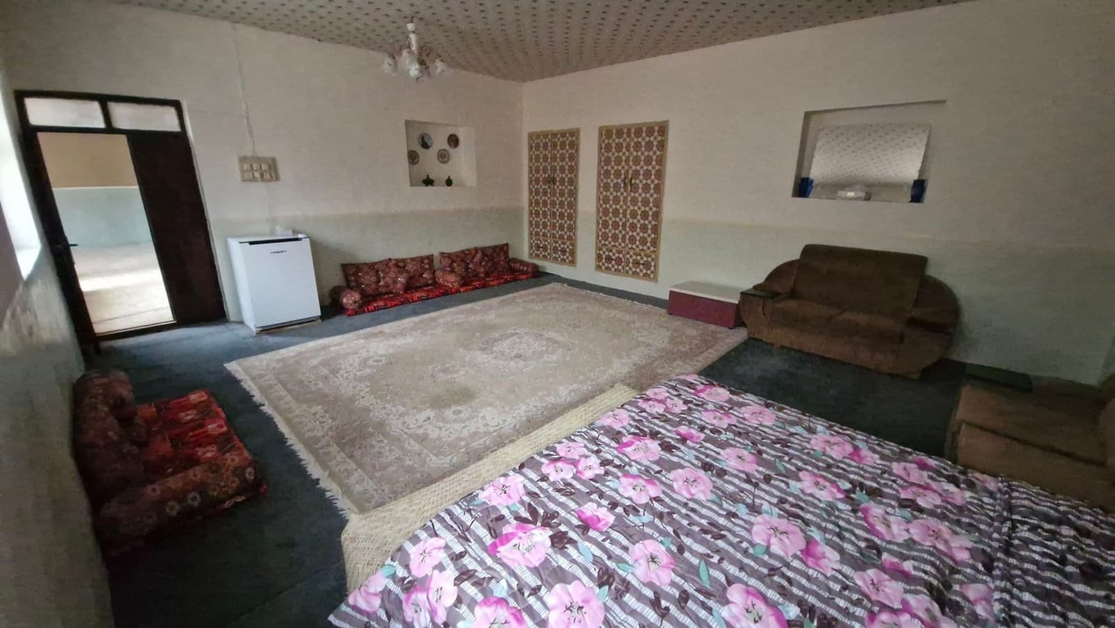 اتاق سنتی با رخت‌خواب محلی و روتختی رنگی بوم‌گردی ریما درگهان قشم