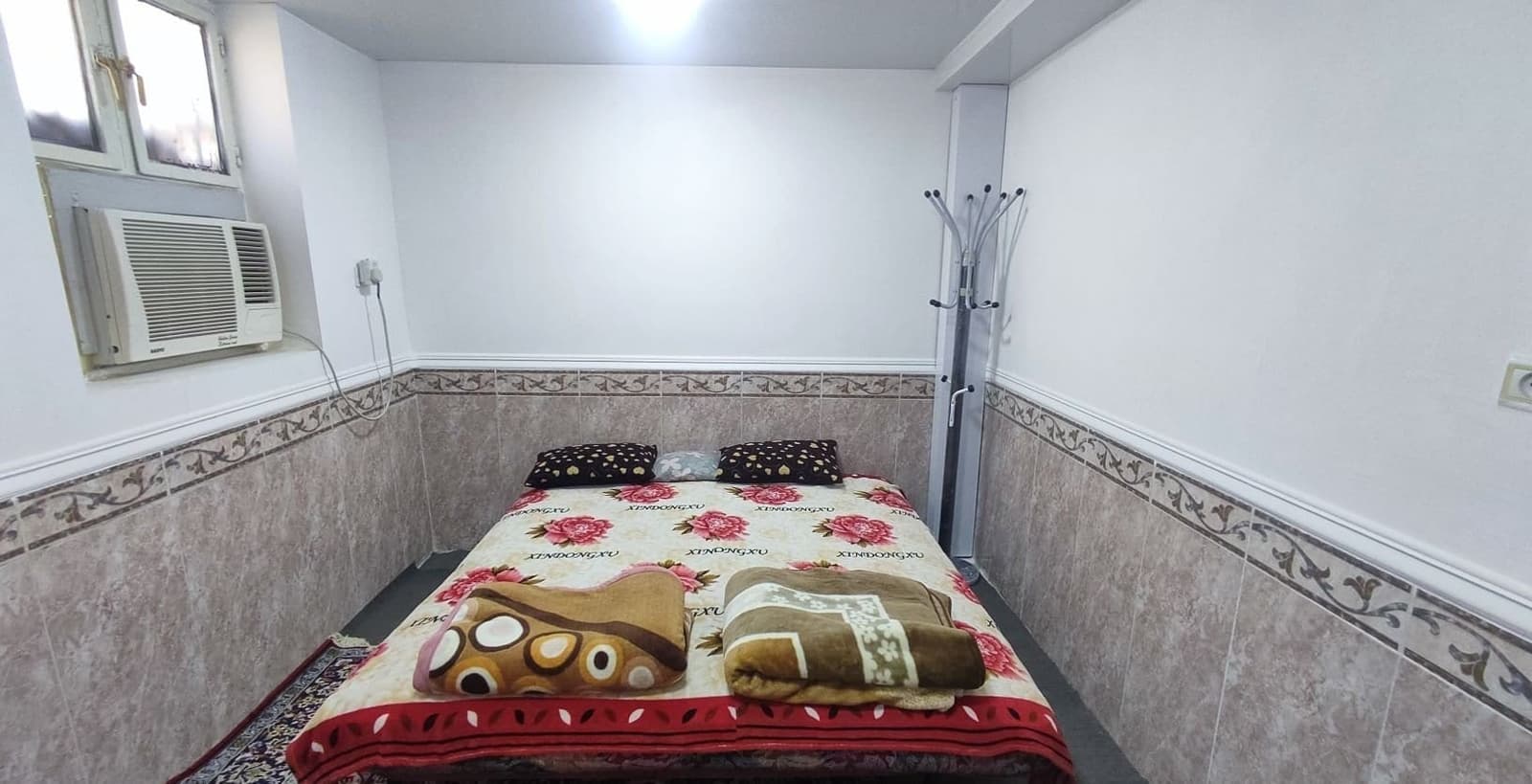 اتاق‌خواب با تخت دونفره و جالباسی در سوئیت خور درگهان قشم