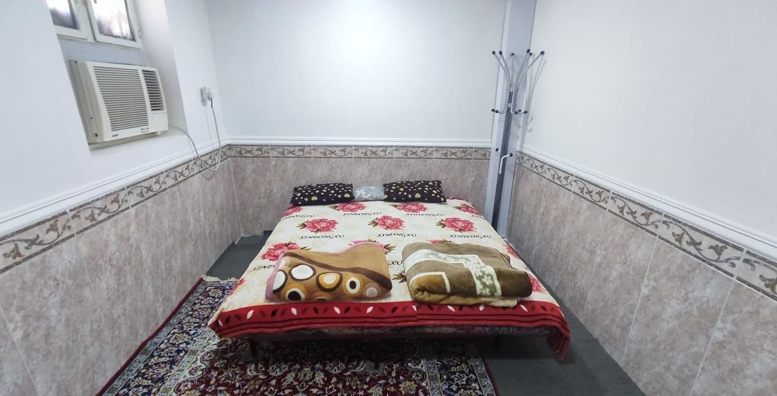 اتاق‌خواب با تخت دونفره و کولر پنجره‌ای در سوئیت خور درگهان قشم