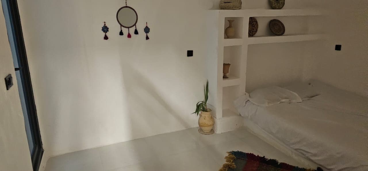 اتاق‌خواب با تخت یک‌نفره و طاقچهٔ گچی تزیینی در ویلا عمارت رستم قشم