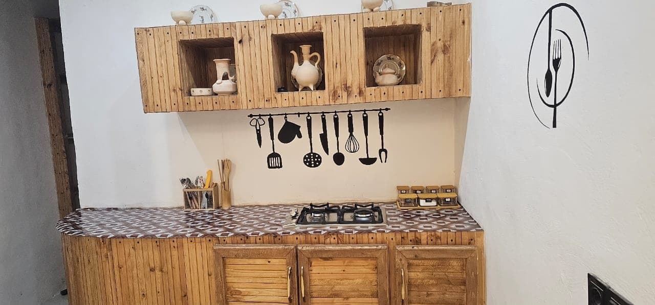 آشپزخانهٔ چوبی با کابینت و اجاق گاز در ویلا عمارت رستم قشم