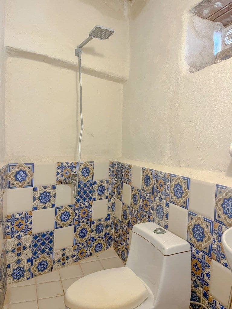سرویس بهداشتی با دیوار کاشی‌کاری‌شده در بوم‌گردی ماتوسکا هرمز